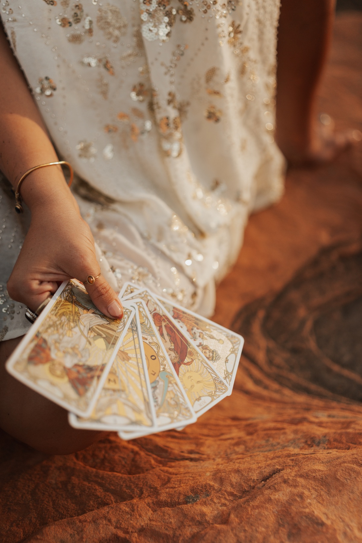 Golden tarot cards held in the afternoon light